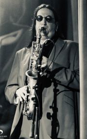 Marcus on stage, playing an alto saxophone